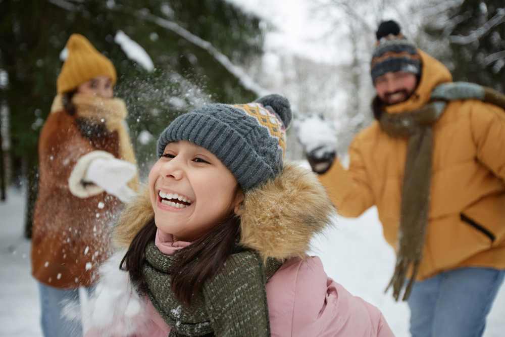 A family throwing snowballs and laughing
