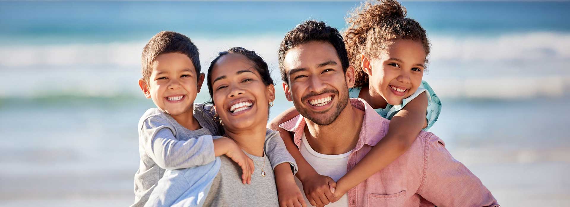 A family smiling on the beach